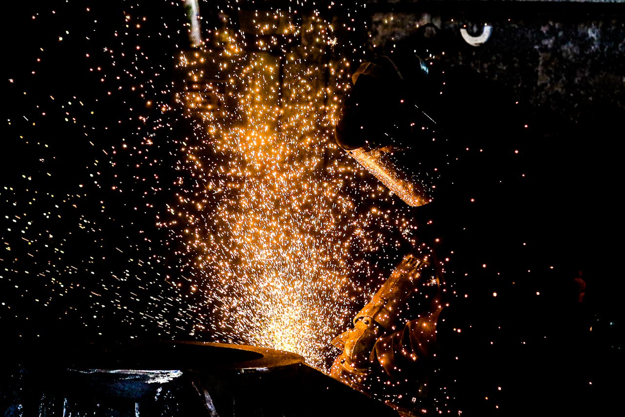 A welder in Sertãozinho, Brazil, working with sparks flying on a black background.
