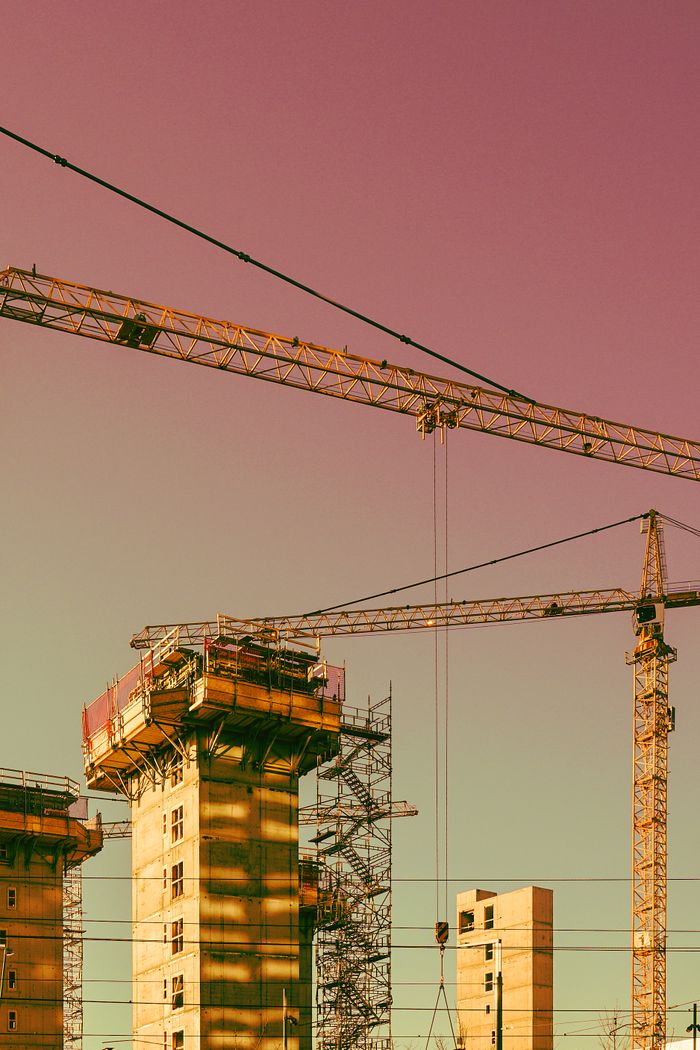 Vertical urban construction scene in Oslo featuring cranes and scaffolding.