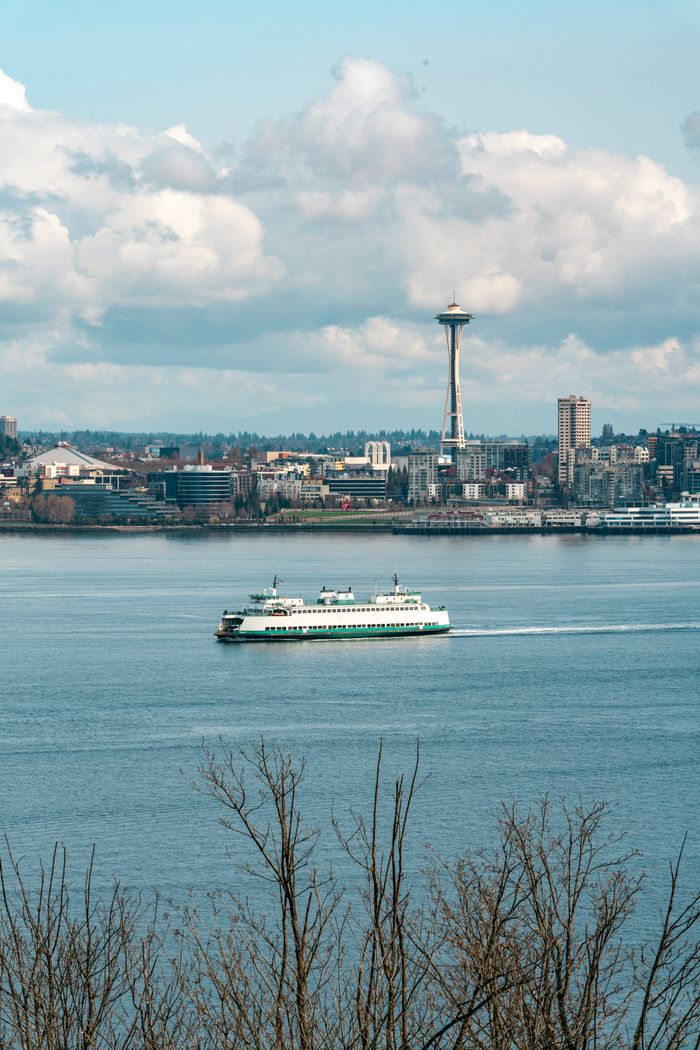 services-03 Beautiful view of Seattle skyline featuring the iconic Space Needle and a ferry crossing the water.