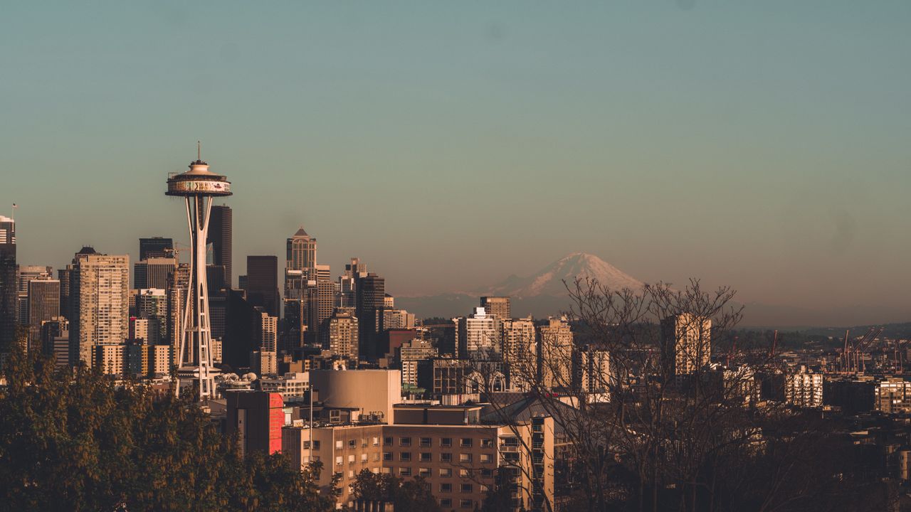 gallery-04 Stunning view of Seattle's skyline featuring the Space Needle with Mount Rainier in the background.