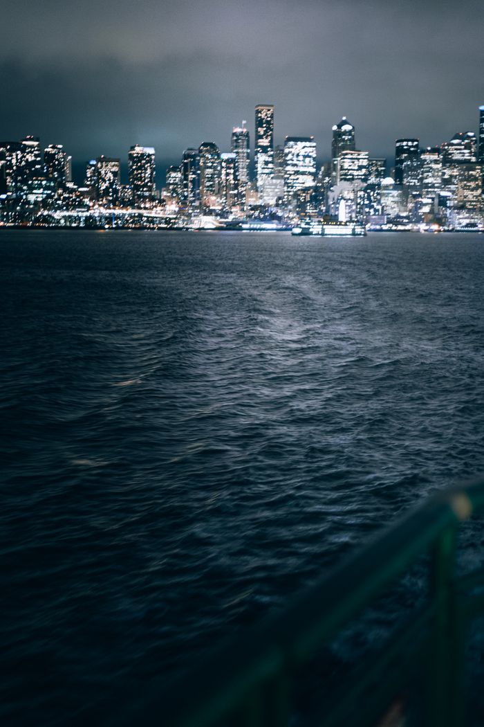 services-01 Moody view of the Seattle skyline at night from the waterfront, capturing urban lights.