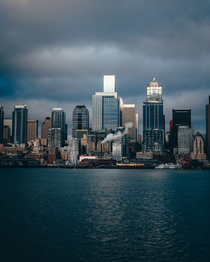 services-04 Moody Seattle skyline with urban architecture and stormy skies overlooking the waterfront.