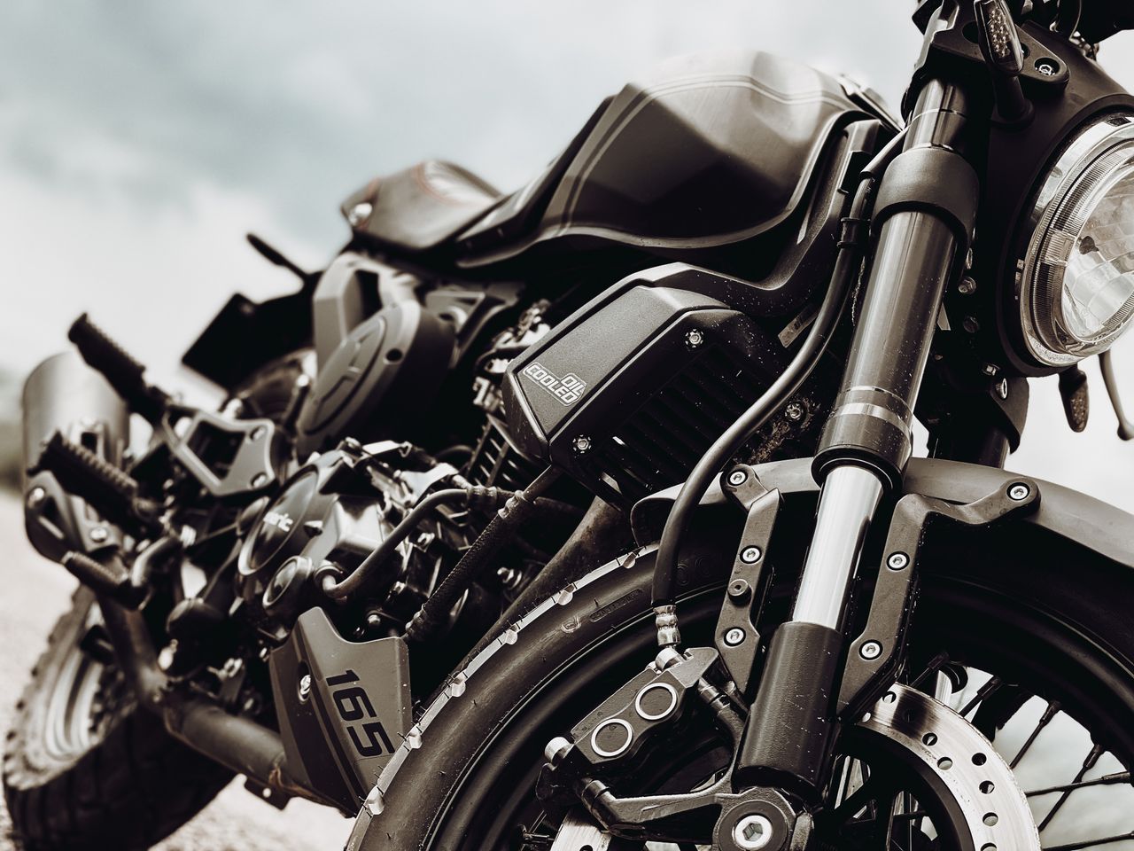 gallery-02 Detailed close-up photo of a sleek parked motorcycle showcasing its modern design and engineering.